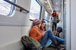 © Agnieszka Olek/Caia Image - Young couple backpacking, riding passenger train