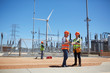 © Trevor Adeline/Caia Image - Engineers using digital tablet at sunny wind turbine power plant