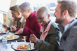 © Chris Ryan/Caia Image - Smiling young woman eating lunch with friends