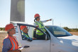 © Trevor Adeline/Caia Image - Engineers at truck at sunny wind turbine power plant