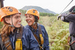 © Trevor Adeline/Caia Image - Happy women friends zip lining