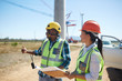 © Trevor Adeline/Caia Image - Engineers with blueprints talking at sunny power plant