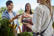 © Trevor Adeline/Caia Image - Woman paying at farmer‚Äôs market