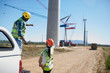 © Trevor Adeline/Caia Image - Engineers on dirt road at wind turbine power plant