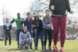 © Sam Edwards/Caia Image - Team cheering woman running in sunny park
