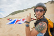 © Trevor Adeline/Caia Image - Portrait confident, carefree male paraglider on beach