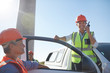 © Trevor Adeline/Caia Image - Portrait smiling, confident female engineer using walkie-talkie at truck
