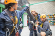 © Trevor Adeline/Caia Image - Women friends high-fiving, preparing zip line equipment