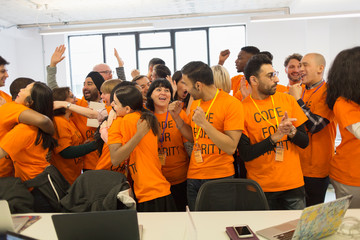 Happy hackers celebrating, coding for charity at hackathon
