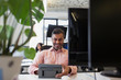 © Sam Edwards/Caia Image - Smiling businessman using digital tablet in office