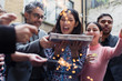 © Sam Edwards/Caia Image - Friends celebrating with man holding birthday cake