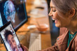 © Chris Ryan/Caia Image - Laughing businesswoman video chatting businessman on digital tablet