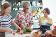 © Robert Daly/Caia Image - Senior women friends cooking in kitchen