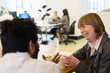 © Martin Barraud/Caia Image - Smiling businesswoman talking with colleague in office