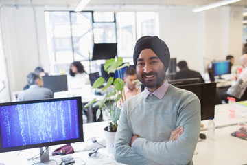 Portrait smiling, confident Indian computer programmer in turban in office