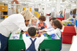 © Trevor Adeline/Caia Image - Teacher and students playing at interactive exhibit in science center