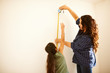 © Himalayan Pics/Caia Image - Mother and daughter measuring wall for project