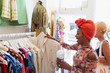 © Tom Merton/Caia Image - Young woman with smoothie shopping in clothing store