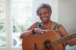 © Robert Daly/Caia Image - Portrait smiling, confident active senior woman playing guitar