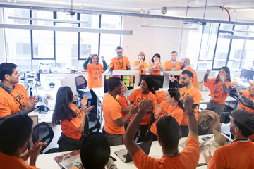 Hackers celebrating, coding for charity at hackathon
