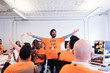 © Sam Edwards/Caia Image - Exuberant hackers cheering, coding for charity at hackathon