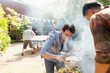 © Tom Merton/Caia Image - Male friends barbecuing in sunny backyard