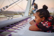 © Trevor Adeline/Caia Image - Serene young woman relaxing on catamaran
