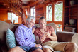 © Trevor Adeline/Caia Image - Father and son using smart phone on cabin sofa