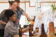 © Tom Merton/Caia Image - Creative designers people designing bottle label in office