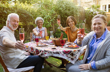 Portrait smiling, confident active senior friends drinking rose wine enjoying lunch at patio table