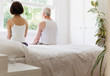 © Tom Merton/Caia Image - Thoughtful senior couple sitting on bed looking out window