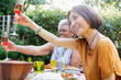 © Tom Merton/Caia Image - Happy active senior women toasting rose wine at garden party