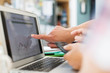© Sam Edwards/Caia Image - Man pointing at investment chart on laptop