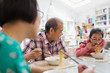 © Sam Edwards/Caia Image - Multi-generation family eating noodles with chopsticks at table