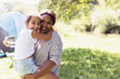 © Sam Edwards/Caia Image - Portrait affectionate mother holding daughter at sunny campsite