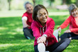 © Tom Merton/Caia Image - Happy active senior woman stretching leg in park