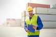 © Agnieszka Olek/Caia Image - Portrait confident dock worker with clipboard at shipyard