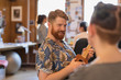 © Tom Merton/Caia Image - Smiling creative businessman playing ukulele in office