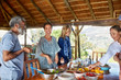 © Trevor Adeline/Caia Image - Happy friends enjoying healthy meal in hut during yoga retreat