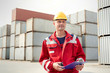 © Agnieszka Olek/Caia Image - Portrait confident dock worker with clipboard and walkie-talkie at shipyard