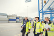 © Rafal Rodzoch/Caia Image - Dock workers and manager walking and talking at shipyard