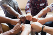 © Tom Merton/Caia Image - Men joining fists in circle in group therapy