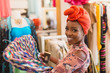© Tom Merton/Caia Image - Portrait smiling, confident young woman in headscarf shopping in clothing store