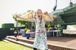© Tom Merton/Caia Image - Portrait playful girl playing with plastic hoop in sunny back yard