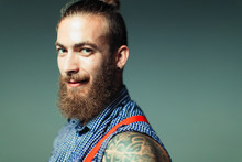 Portrait confident, cool male hipster with beard and shoulder tattoo