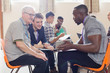 © Tom Merton/Caia Image - Men talking in group therapy in community center