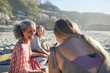 © Trevor Adeline/Caia Image - Smiling women friends talking on sunny beach during yoga retreat