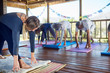 © Trevor Adeline/Caia Image - Female instructor leading yoga class in hut during yoga retreat