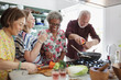 © Robert Daly/Caia Image - Active senior friends cooking in kitchen