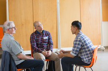 Men Talking And Listening In Group Therapy